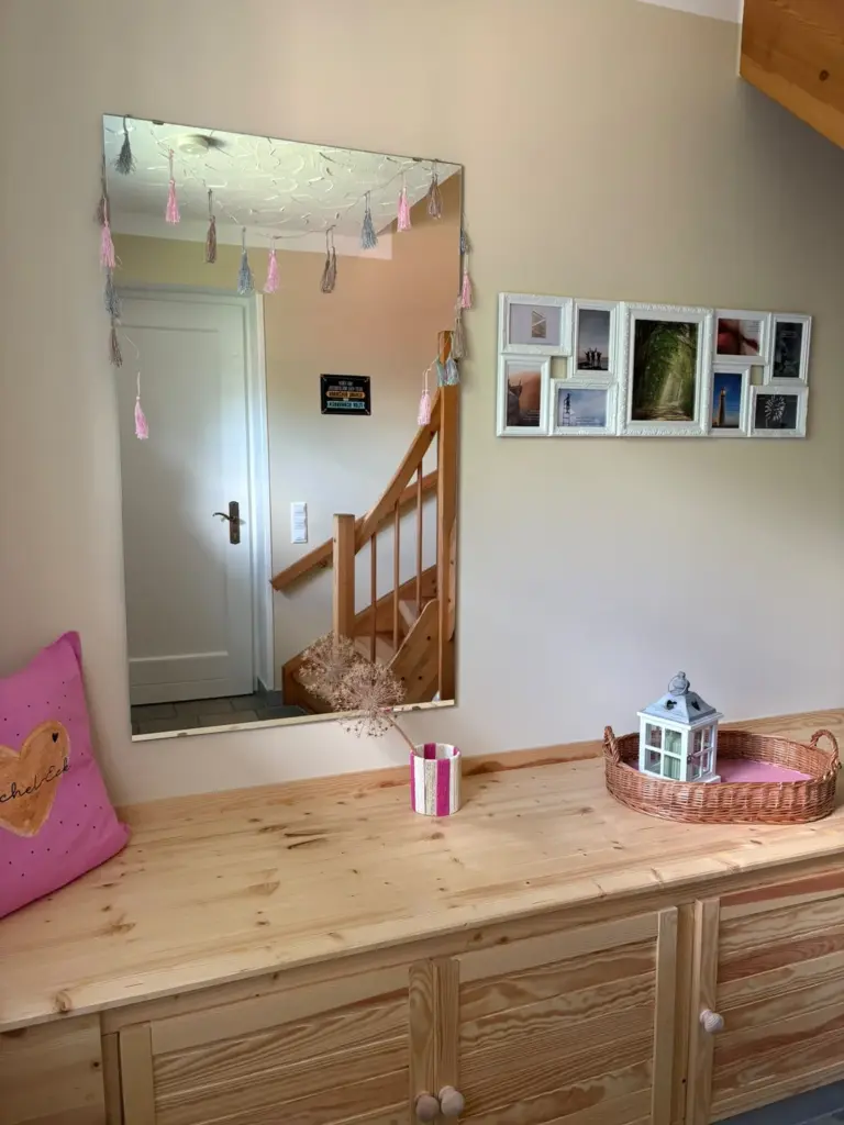 Flur-Sideboard mit Wandspiegel, Fotocollage und dem Namensgeber-Kissen