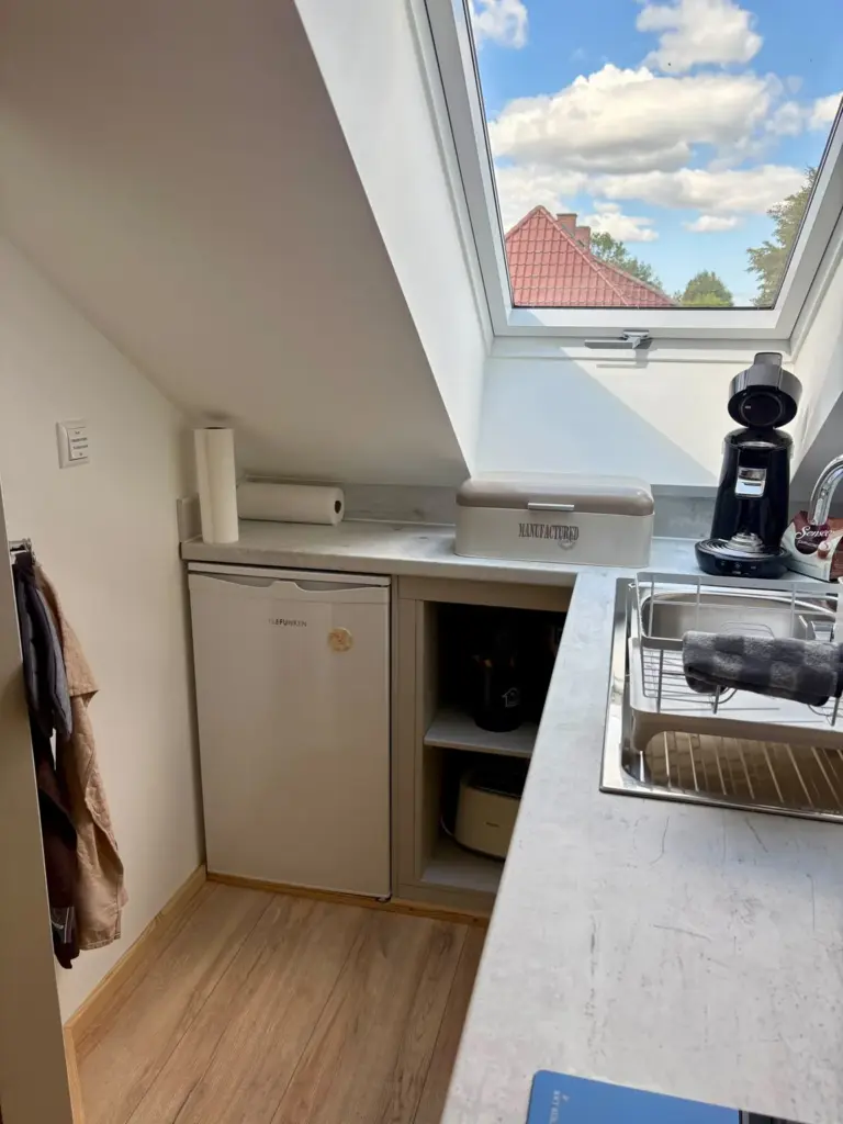 Kuechenzeile mit Kuehlschrank neben dem Dachfenster
