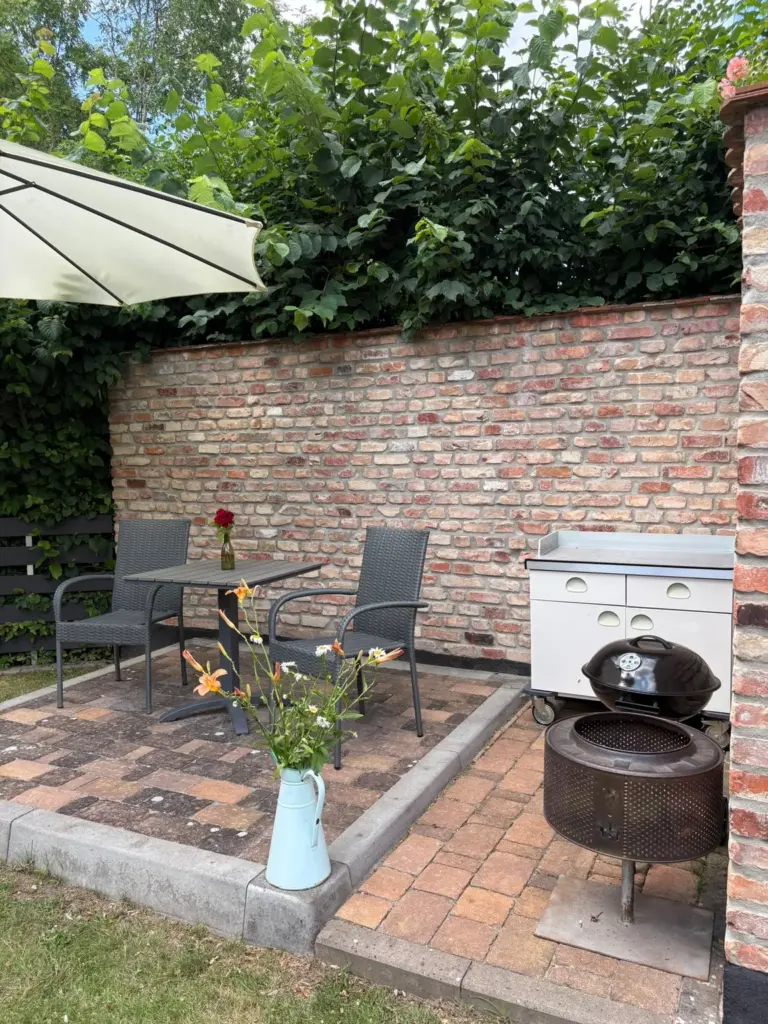 Terrasse mit Sitzgruppe, Grill und Sonnenschirm